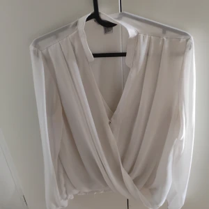 Vit tunika - Vit tunika i storlek l, har en undertröja under samt en knapp fram, är knappt använd
