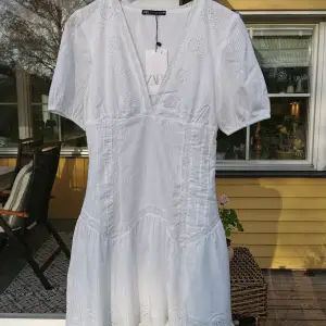 Romantisk vit Zara-klänning stl S. Inköpt för 1 år sedan, aldrig använd, glömde att returnera den, priset var 399 kr. Kort modell, underkjol, dragkedja i sidan, resår i ärmen, hela klänningen i bomull. 