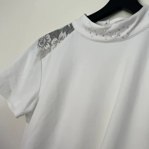 Tävlings ridtröja  - En helt ny tävlings ridtröja med spets och sten detaljer. Aldrig använd men prislappen har jag tyvärr slängt. Den är i storlek 158-164, men den är stor i storleken så skulle mer säga att den är XS. Skriv om du har frågor💕