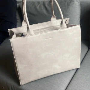 Ulrika Design stor väska  - En stor ljus beige väska från Ulrika Design. Använd några gånger. Fint skick förutom märke på baksidan, de bild. Höjd: 30cm Bredd: 38cm Djup: 15cm
