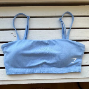 Gymshark bandeau sport bh - Säljer denna superfina bandeau sport bh som tyvärr är lite liten på mig. Den har en mindre fläck på insidan och banden men inget som syns när man har på den. Hade två i samma färg av konstig anledning men jag använder samma bild från förra annonsen 🥰