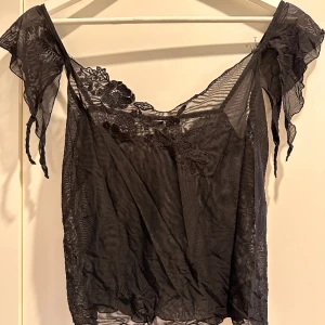 Genomskinligt linne - Blom mönster på bröstet som är väldigt gulligt. Aldrig använt! Storlek M