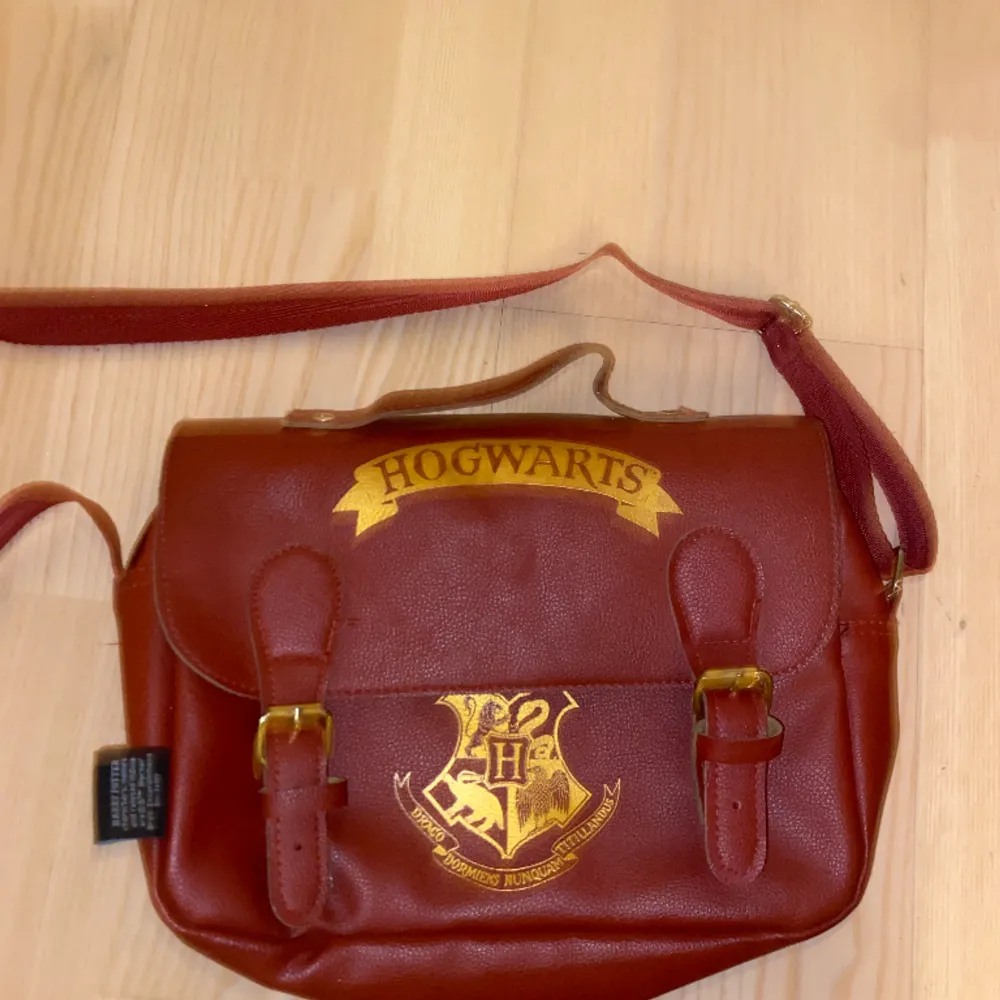 Vinröd väska med Hogwarts tryck som är jätte cool. Säljer eftersom att färgen inte klär mig och är i jättebra skick -som ny! Säljer ganska dyrt pga var dyr 😜 men pris kan diskuteras vid snabb affär. Skriv för fler bilder 💗. Väskor.