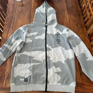 Välanvänd dope hoodie i grå kamouflage färg. Hoodien är i storlek L och fortfarande i bra skick. 