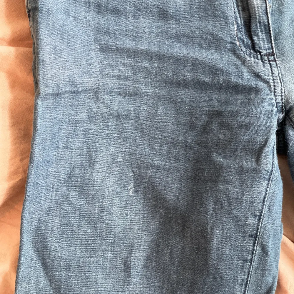 Lågmidajde jeans i väldigt tunt, lite fladdrigt tyg med spänne baktill. Liten skråma framtill (se bild 3) annars fint skick.. Jeans & Byxor.