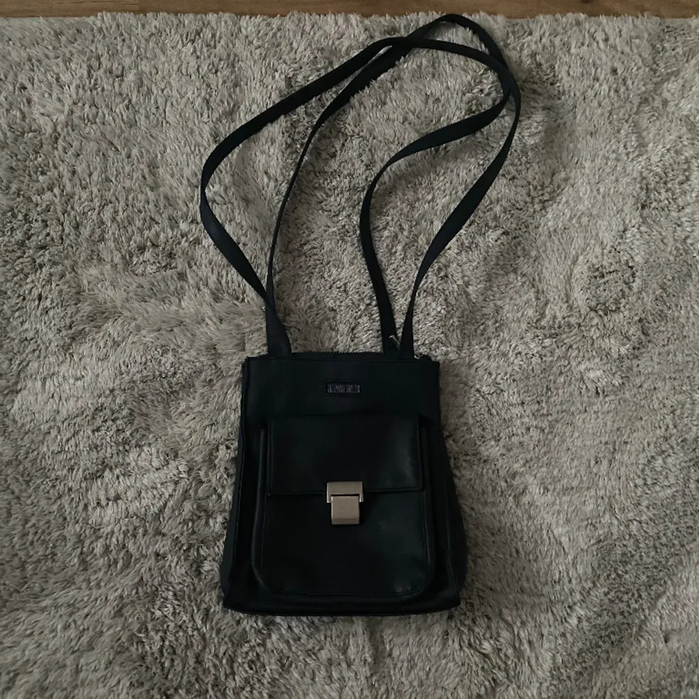 Säljer denna snygga mörkblåa axelremsväskan eftersom den inte kommer till användning . Väskor.