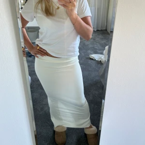 Långkjol - Säljer denna superfina vita långkjol från NA-KD, köpt förra året. Endast använd en gång och säljer pga att den inte kommer till användning! Den är i storlek XS men väldigt stretchig i tyget! Säljer inte under 150 kr!