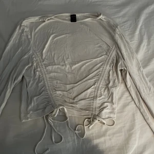 Topp med detaljer - Fin topp med snören som man knyter Om du vill ha fler/bättre bilder så är det bara att skriva ett meddelande så skickar jag gärna!