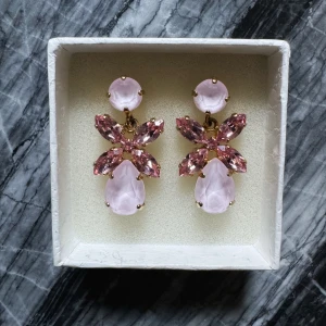 Mini Dione Caroline Svedbom örhängen  - Mycket vackra lila örhängen i absolut nyskick.   Modell: Mini Dione  Storlek: 35 x 18 mm Plätering: 18K Guld Nypris: 1395kr