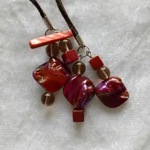 Handgjort halsband med brunt mockaband och vinröda pärlor
