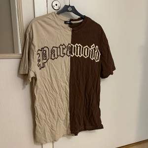 Snygg oversized T-shirt i brun och beige/benvit med texten ”paranoid” 🟤🥥🟤 Storlek M. 100% bomull.