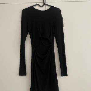 Säljer denna svarta klänning med lite detaljer på magen i storlek XS. Aldrig använd så prislappen är kvar 