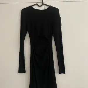 Säljer denna svarta klänning med lite detaljer på magen i storlek XS. Aldrig använd så prislappen är kvar 