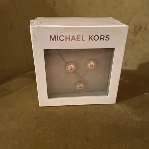 Michael Kors smyckes-set - Michael Kors örhängen och halsband-set i roseguld. Oöppnad förpackning!