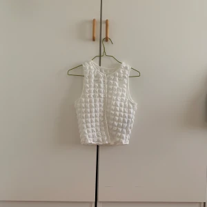 Supersöt sommartopp! - En topp som är söt, somrig och perfekt för midsommar eller nån annan härlig sommarfest! Vit, texturerad, går att knäppa eller att ha öppen som en väst