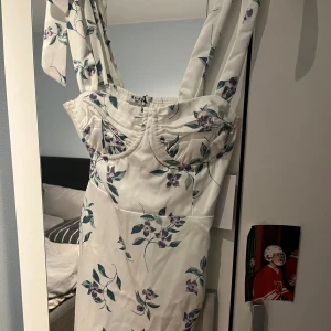 Vit klänning  - Blommig klänning, säljer pga för liten, storlek 36, aldrig använd 