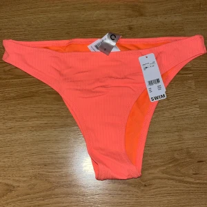 Orange ribbad bikiniunderdel - Ribbad orange bikiniunderdel från Cubus, lappar kvar Strl S