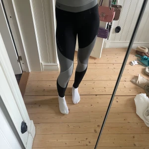 Nike träningstights - Svarta och gråa träningstights ifrån Nike. Använda några gånger men väldigt fint skick fortfarande. Nypris ca 550kr. Storlek XS. Pris går att diskutera🥰