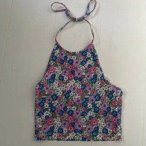 Blommig tröja  - Blommig tröja med öppen rygg med knyte i nacken  Helt oandvänd