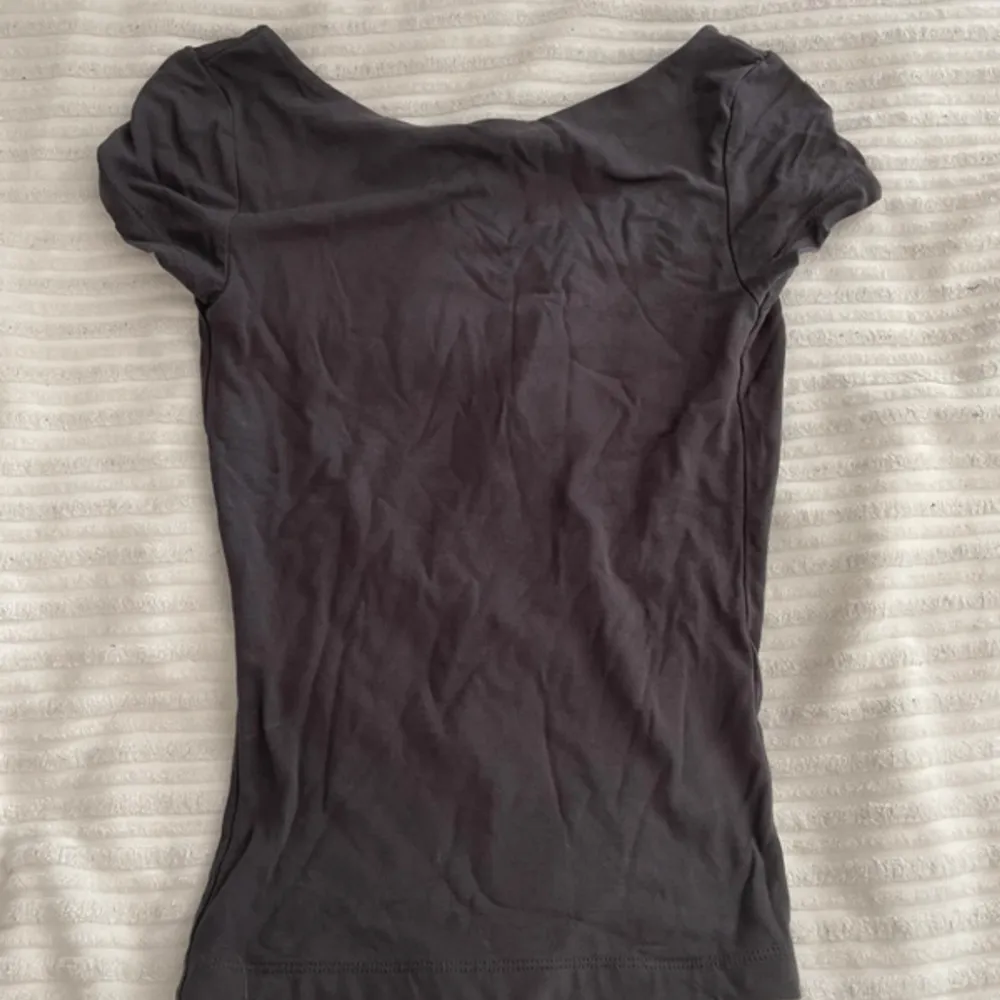 Säljer denna snygga gråa t-shirten med öppen rygg som är perfekt nu till sommaren🩶. T-shirts.