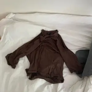 En brun tröja som är öppen i axlarna! I storlek S från Lindex