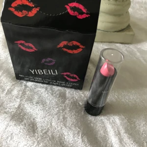 Yibeili Amplified Creme Lipstick - Säljer en snygg och krämig läppstift från Yibeili. Läppstiftet kommer i en elegant svart förpackning med färgglada läppavtryck. Färgen på läppstiftet är en härlig rosa nyans som passar perfekt för både vardag och fest. Läppstiftet är återfuktande och ger en fin glansig finish.      finns fler kvar. 39kr/st , sammafrakt 