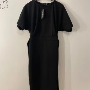 Midi svart klänning - Helt ny midi klänning i svart! Prislapp kvar Köpte den från Booho, men den har inte kommit till användning.  Storlek : XS / 34 Pris 100kr