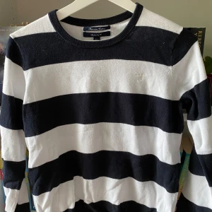 Svartvit randig tröja från GANT - Säljer en snygg och stilren svartvit randig tröja från GANT. Tröjan är gjord av premium bomull och har långa ärmar. Perfekt för både vardag och fest! 🖤🤍