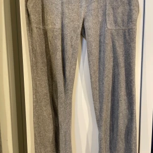 Grå juicy byxor - Säljer ett par grå Juicy byxor. Byxorna är i storlek L men har sytt om de till låg midjade och sytt in de runt benen. Skulle säga att de har samma passform som ett par i S nu. Det finns ett litet hål vid sömmen efter som att jag sydde om de till lågmidjade och de blev snett sytt.