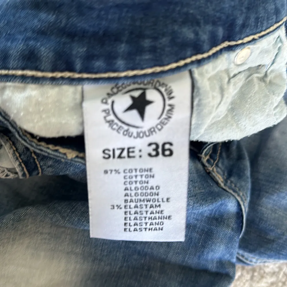 Säljer ett par snygga blå jeansshorts från Place du Jour i storlek 36. De är högmidjade och har en cool knappdetalj framtill. Perfekta för sommaren! Shortsen är i nyskick och har en normal passform. Materialet är mestadels bomull med lite elastan för extra komfort.. Shorts.