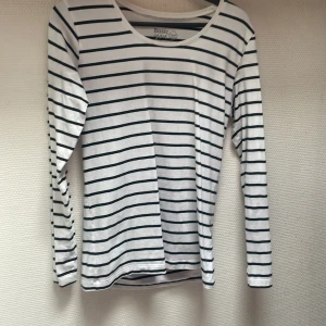 Vit och svart randig tröja från Basic You - En vit och svart randig tröja från Basic You tillverkad av ekologisk bomull. Tröjan har långa ärmar och en rund halsringning.