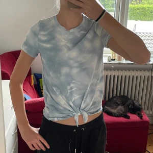 Blå och vit knyt-topp från Abercrombie Kids - Säljer en superfin blå och vit knyt-topp från Abercrombie Kids. Toppen har korta ärmar och ett snyggt knyt framtill. Perfekt för sommaren och passar till både jeans och shorts. Toppen är i nyskick och väldigt bekväm att ha på sig. 🌸