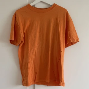 Orange t-shirt från Biltema - Säljer en orange t-shirt från Biltema i storlek M. Den är gjord av bomull och har en normal passform.  T-shirten är i bra skick och har korta ärmar. Skicka ett meddelande om du är intresserad! 🧡