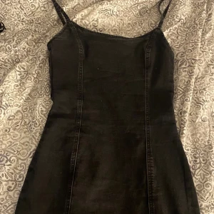 Svart jeans klänning  - Säljer en svart jeans klänning från hm, har inte använt den på jätte länge så vill bara bli av med den. Den är i helt okej skick kanske lite urtvättad. Man får en väldigt fin figur av den men den blir ganska kort på mig som är 170.