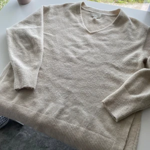 En fin beige tröja - Jag säljer en jätte fin beige tröja från hm med urringning och 2 slittar på varsin sida av tröjan. Den är i storlek xs men den har en lite större passform så den är säkert jättefin på många!