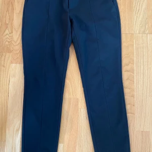 Svarta kostymbyxor strl 36 fr Hope modell Pete trouset - Svarta kostymbyxor strl 36 fr Hope modell Pete trouset.  Sparsamt använd och i fint begagnat skick.  Mått Midjan: ca 40 cm Längd från grenen och ner: ca 71 cm  54% polyester, 44% ull och 2% elastan