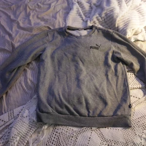 Grå tröja från Puma - Säljer en grå tröja från Puma. Den är i normal passform och har långa ärmar. Tröjan är i bomull och har en liten skada på ena ärmen. Perfekt för höst och vinter. Köp direkt eller ge prisförslag 💛