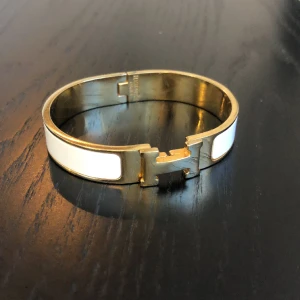 Armband klassiskt - Vitt med guld Knappt använd I fint skick. Inte äkta!