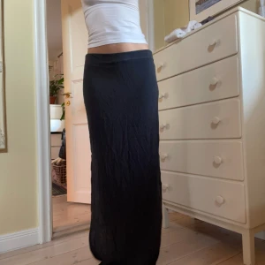 Lång svart maxikjol - Lång maxikjol med slit på sidorna. Från vero moda, midjemått 84cm längd 100cm, jag är 173!