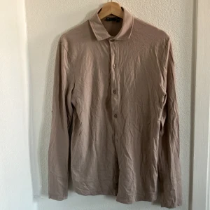 Beige Asos-skjorta med stretch - Beige stretchig skjorta från asosdesign. Väldigt skön i tyget. Lite längre än vanlig medium strl. Fint skick och inte mycket använd.   100% organisk bomull.