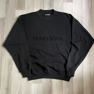 Vintage Bootleg Hugo Boss Tröja - Vintage Bootleg Hugo Boss Crewneck. Fint skick. Size L, men passar bra på mig som en S/M med. Sjuk krage. Skriv om fler bilder eller mått önskas. Se mina andra annonser, ordnar bättre pris vid köp av flera plagg!
