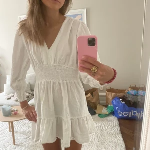 Vit kort klänning från zara - Säljer denna vita fina klänningen från zara, tror inte den säljs längre.  Använt den ett fåtal gånger på konfirmation och liknande firanden. Den har fått ett hål som lätt går att laga då det ligger mitt på en söm (kolla sista bilden)😚💘