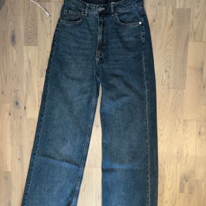 Mörkblåa högmidjade vida jeans - Mörkblåa högmidjade vida jeans från HM Divided i storlek 36. Använda men knappt tecken på det. 