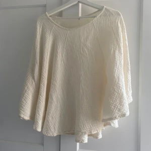 Vit-beige poncho - Vit-beige poncho med ärmar, jättefin att ha en sommarkväll när det blir lite kallare