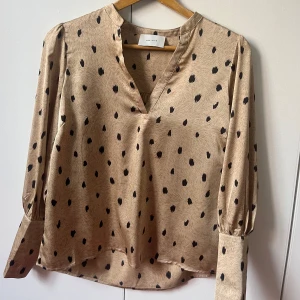 Blus, prickig blus, Neo noir - Superfin blus från Neo noir i bra skick. Guldig färg med svarta prickar. 100% polyester 