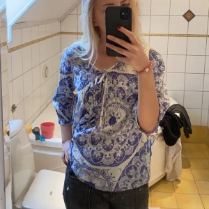 Blus - Säljer denna jättefina blåvit mönstrade blusen ifrån Flash Woman! Använd 1 gång, så inga defekter! 🌸