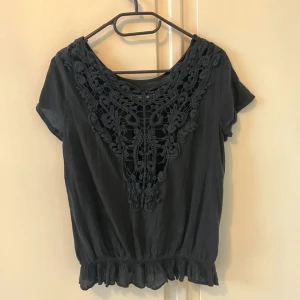 Blus / t-shirt - Svart t-shirt / blus med broderad rygg. Fint skick, bara använd ett fåtal gånger.