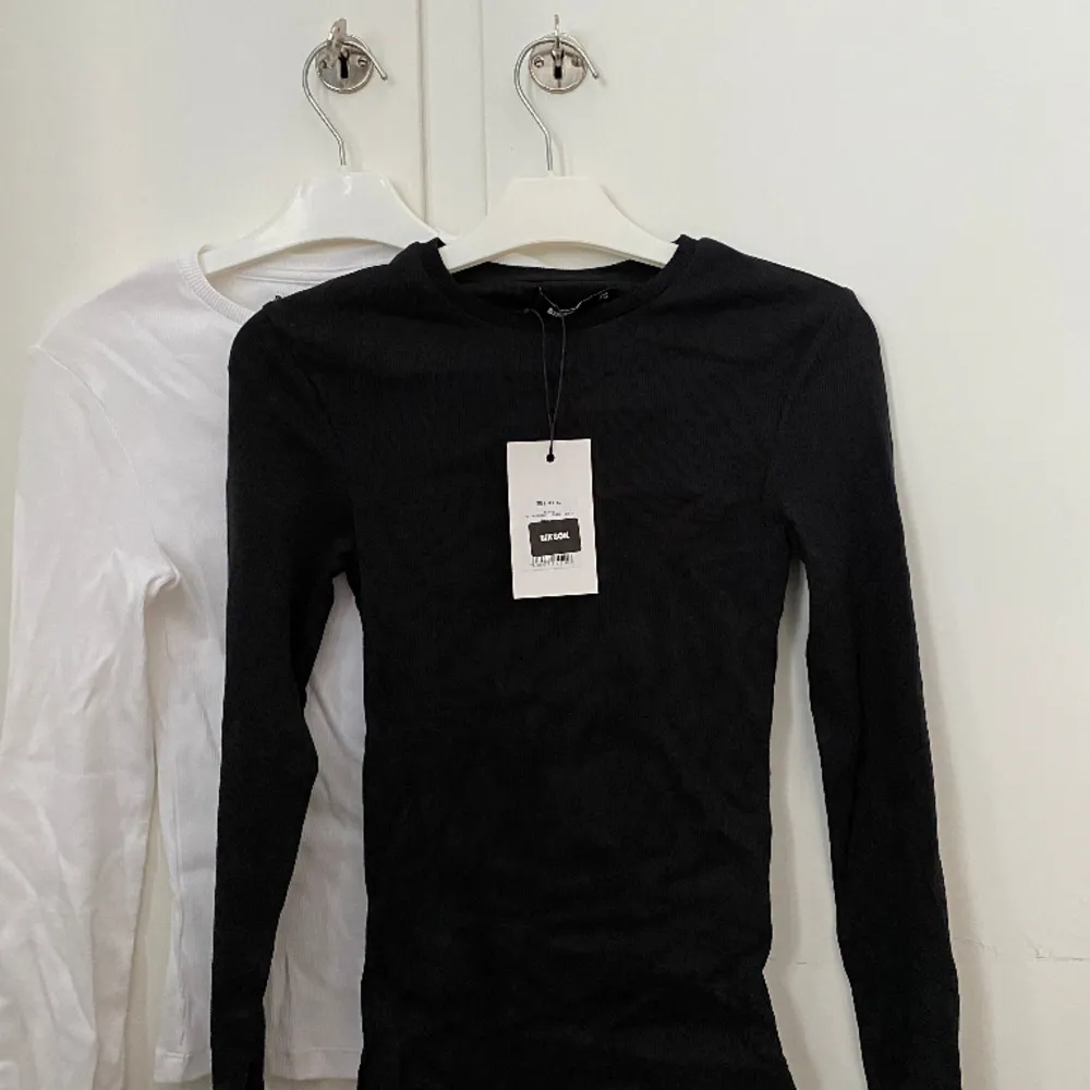 En svart och vit basic tröjor i ribbat tyg från bikbok i storlek xs. Aldrig använda🌷båda för 80kr eller en för 50kr🤩. T-shirts.