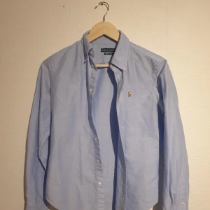 Ralph lauren skjorta XS - Ljusblå ralph lauren skjorta som säljs pga alldeles för liten. Använd max 3 ggr. Passar inte större än XS