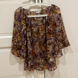 Fin blus blommig blus  - Fin blommig blus, mycket sparsamt använd. Vackert blommigt mönster i bruna-beiga nyanser.